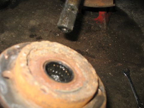 1995 Ford C-350 (Centurion Conversions) - Close-up of a heavily rusted wheel hub and axle shaft, suggesting a vehicle part in need of repair or replacement.