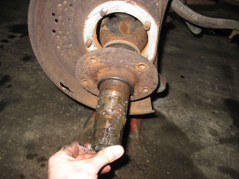 1995 Ford C-350 (Centurion Conversions) - Close-up of a heavily corroded front wheel hub and spindle assembly, likely requiring repair or replacement.