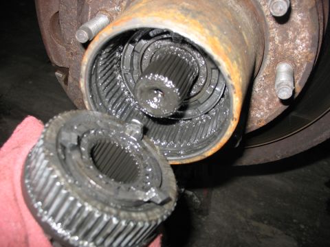 1995 Ford C-350 (Centurion Conversions) - The internal splines of a vehicle's front hub assembly are exposed, with the locking mechanism held in a hand.