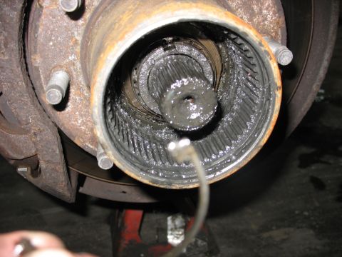 1995 Ford C-350 (Centurion Conversions) - Close-up view of a front axle hub, revealing a splined shaft covered in grease, indicative of a front axle rebuild.