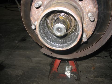 1995 Ford C-350 (Centurion Conversions) - The inner workings of a vehicle's front wheel hub are exposed, resting on a jack stand.