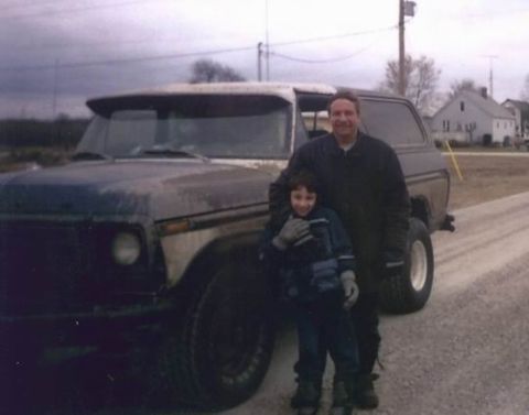 1978 Ford Bronco - A man and child pose in front of a 1978 Ford Bronco on a cloudy day.