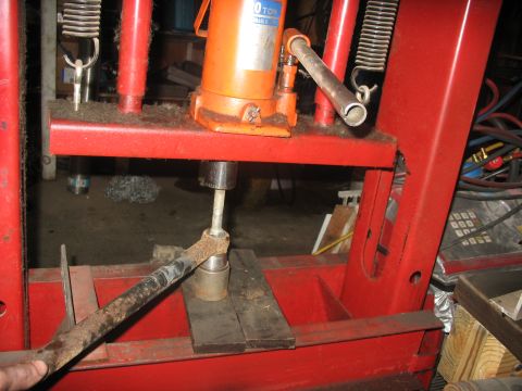 1995 Ford C-350 (Centurion Conversions) - A hydraulic press is used to work on a rusty automotive part, likely a tie rod end.