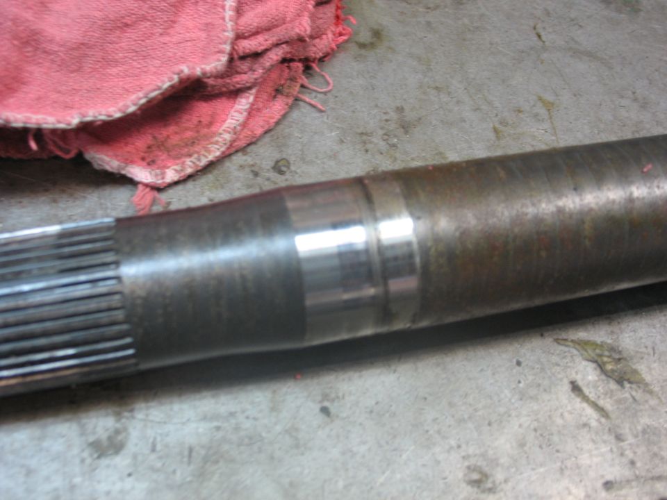 Metal shaft with splines on the left and two distinct wear bands on the right
