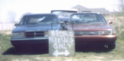1978 Ford Bronco - A sign indicates "BRONCO'S PARKING ONLY" between two parked vehicles.