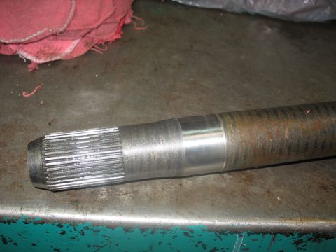 1995 Ford C-350 (Centurion Conversions) - Close-up of a metal axle shaft with visible wear and splines.
