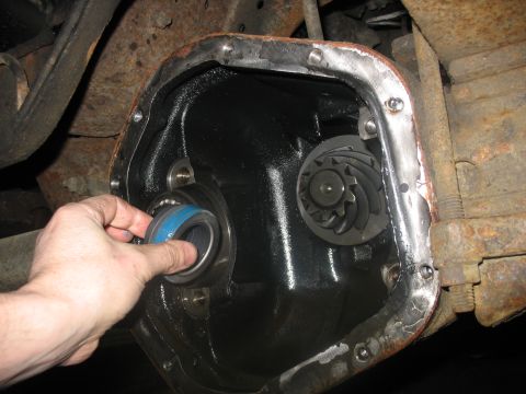 1995 Ford C-350 (Centurion Conversions) - A hand installs a bearing into the differential housing of a vehicle, revealing internal gears.
