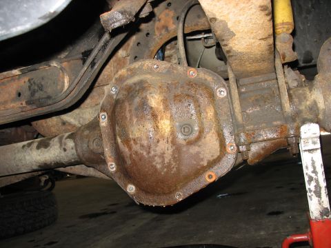 1995 Ford C-350 (Centurion Conversions) - Close-up of a rusty rear axle differential cover, likely needing service or replacement.