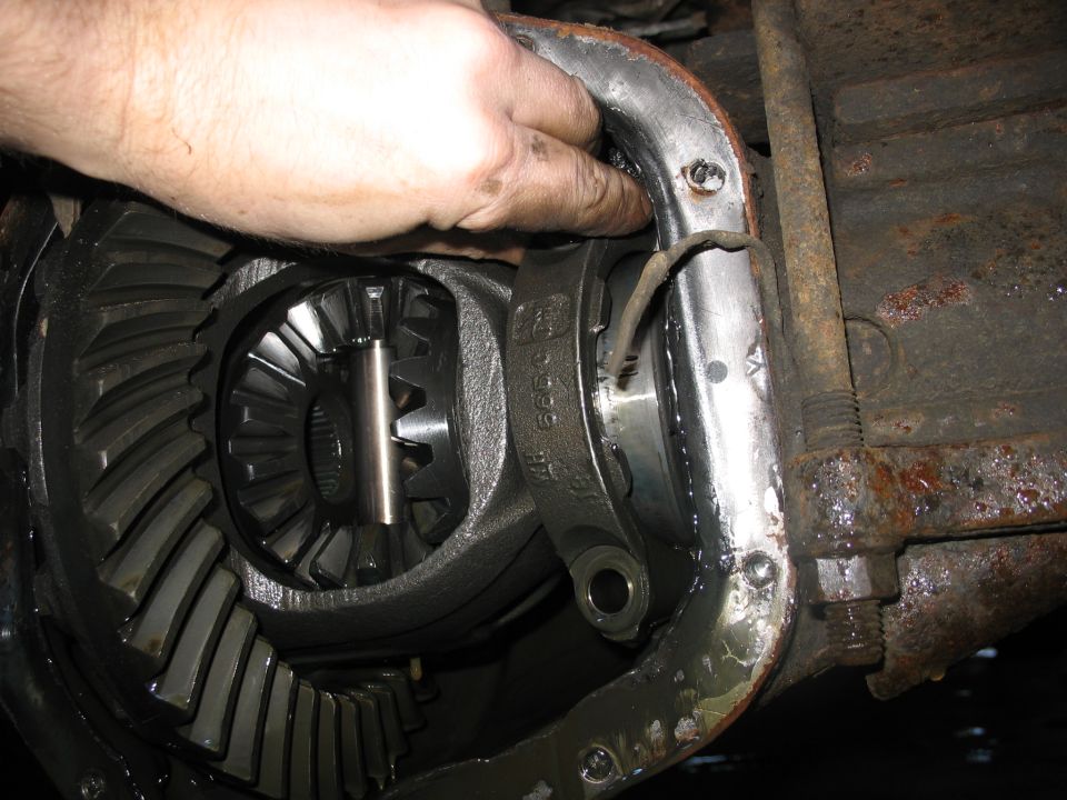 Close-up of differential gears with a hand reaching in