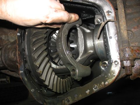 1995 Ford C-350 (Centurion Conversions) - A mechanic's hand is shown working on the internal gears of a vehicle's differential.