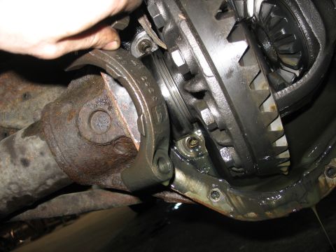 1995 Ford C-350 (Centurion Conversions) - Mechanic's hand adjusting a part of the differential assembly, showing gears and driveshaft.