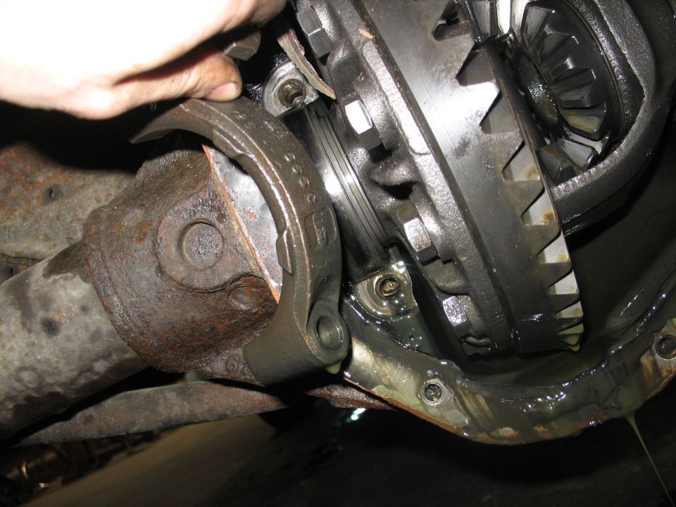 Close-up of differential gears and driveshaft connection being worked on