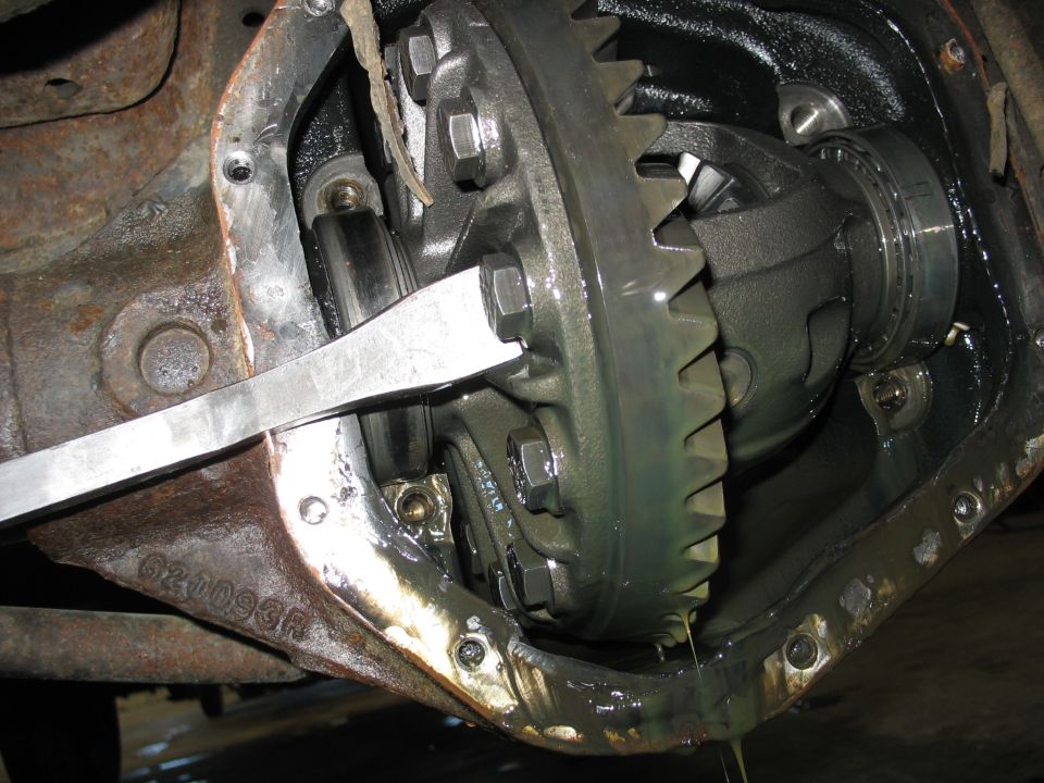 Differential gear assembly with a metal tool inserted, showing gears and bearings. Part number G20093R visible