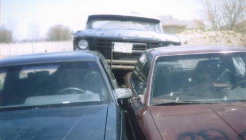 1978 Ford Bronco - Two sedans are parked nose-to-nose, with a truck visible behind them.