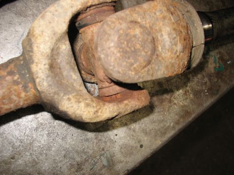 1995 Ford C-350 (Centurion Conversions) - Close-up of a heavily corroded driveshaft universal joint, indicating potential mechanical issues.