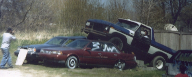 Blue and white 1978 Ford Bronco on top of a maroon sedan