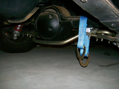 1978 Ford Mustang II - A blue tie-down strap is attached to the sway bar near the rear axle of a vehicle.