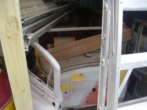 1969 Lincoln Continental - The interior of a car is seen, with parts of the door frame and dashboard visible, suggesting it is under construction or being stored.