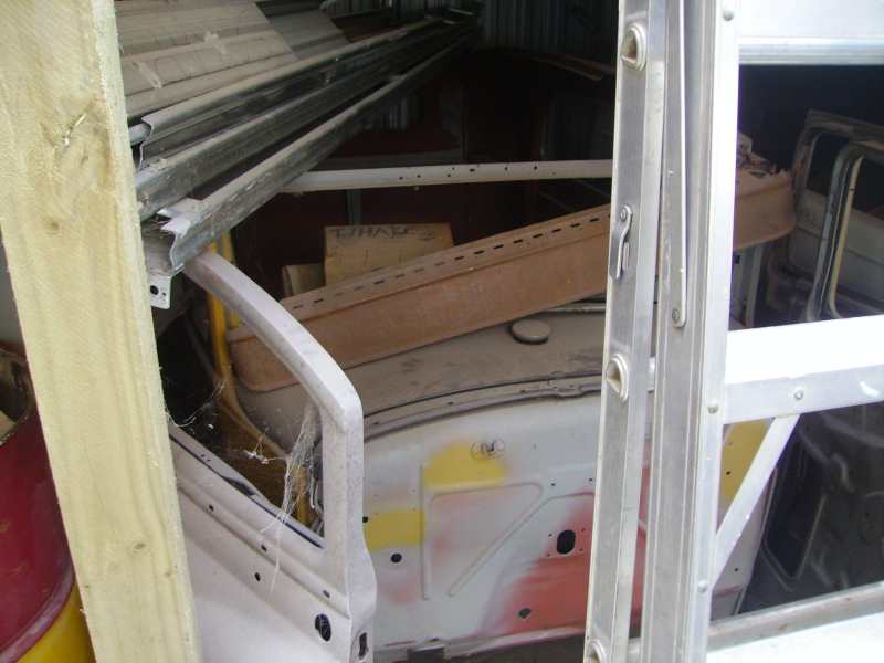 Interior of a car with door frame and dashboard visible, covered in debris