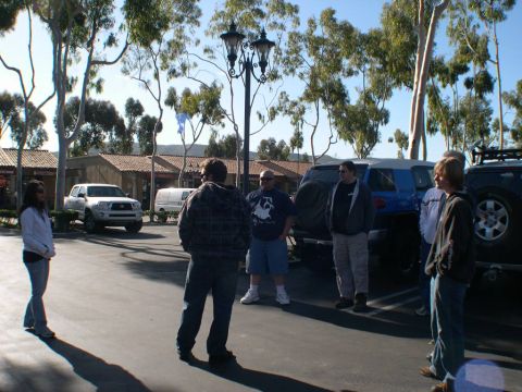 2007 Toyota FJ Cruiser - People gather in a parking lot with several SUVs visible under trees and near buildings.