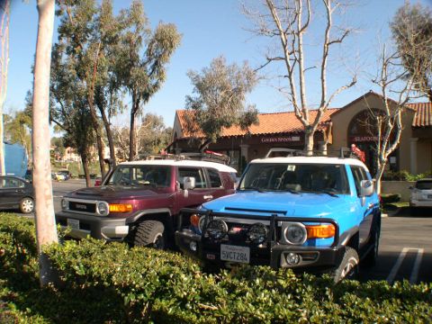 2007 Toyota FJ Cruiser - Two Toyota FJ Cruisers are parked in front of a building with a Spanish-style roof.