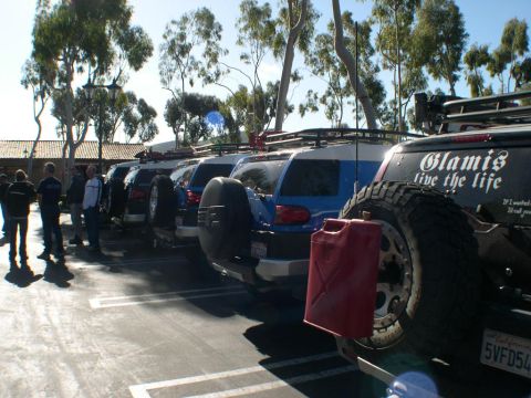 2007 Toyota FJ Cruiser - A line of FJ Cruisers are parked in a lot, some with roof racks and external fuel cans.