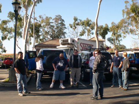 2007 Toyota FJ Cruiser - A group of people stand around several Toyota FJ Cruisers in a parking lot.