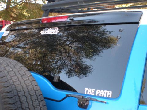 2007 Toyota FJ Cruiser - A sticker reading 'THE PATH' is visible on the rear window of a blue SUV, with a spare tire mounted on the back.