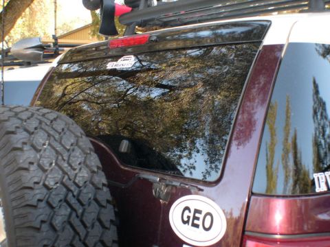 2007 Toyota FJ Cruiser - The rear of a maroon SUV, possibly a 2007 Toyota FJ Cruiser, is visible with a spare tire and roof rack.