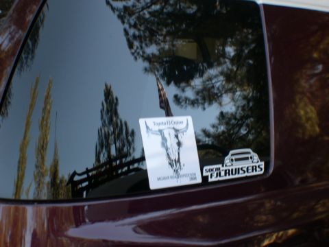 2007 Toyota FJ Cruiser - Sticker on a dark red vehicle window shows 'Toyota FJ Cruiser' and 'Mojave Road Expedition 2008'.