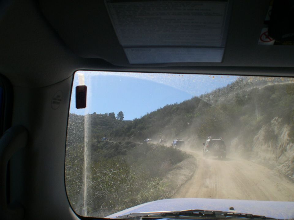 Dusty dirt road with multiple SUVs