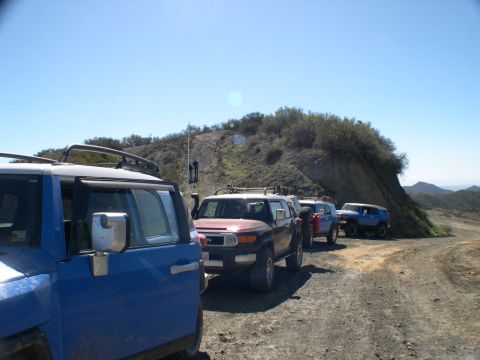 2007 Toyota FJ Cruiser - Several Toyota FJ Cruisers are lined up on a dusty trail, ready for an off-road adventure.