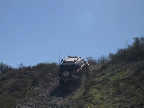 2007 Toyota FJ Cruiser - A black 2007 Toyota FJ Cruiser navigates an off-road trail on a sunny day.
