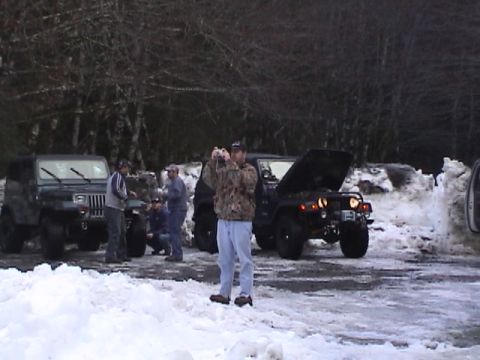 2005 Jeep Wrangler - A group of Jeeps are gathered in a snowy landscape, with one vehicle's engine exposed for inspection.