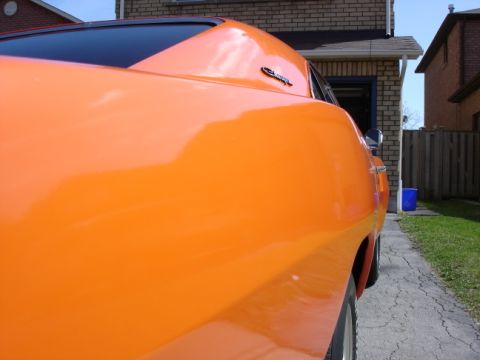 1991 Ford Bronco - Close-up side view of an orange car, highlighting its body lines and glossy finish.