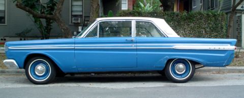 1991 Ford Bronco - This blue and white sedan, likely from the early 1960s, is parked curbside.
