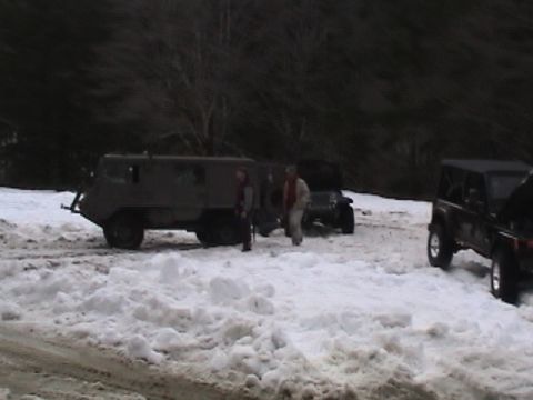 2005 Jeep Wrangler - Multiple vehicles are parked in a snowy area with trees in the background.