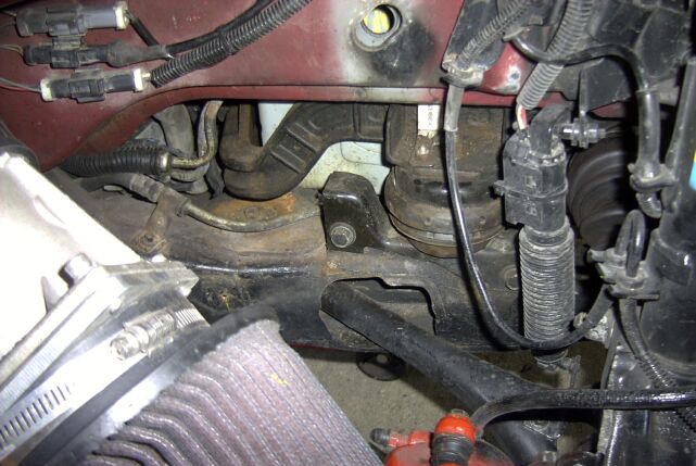 Engine bay hoses, wiring, and mounts visible