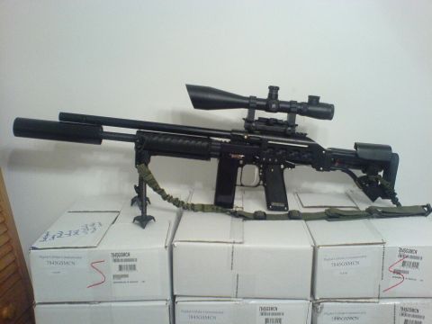 1985 Ford Bronco - A sniper rifle with a scope and bipod is displayed on top of several boxes.