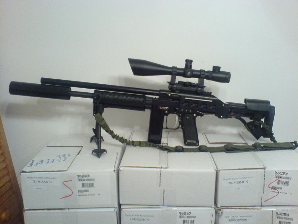 Sniper rifle with scope, bipod, and suppressor, resting on boxes