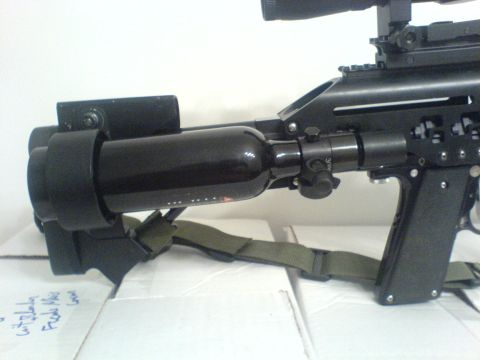 1985 Ford Bronco - A close-up view of a paintball gun's accessories, including a CO2 tank and scope.