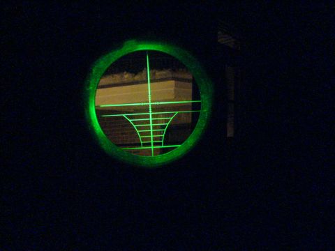 1985 Ford Bronco - A view through a scope shows green crosshairs superimposed over a building at night.