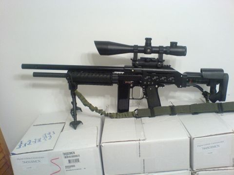 1985 Ford Bronco - A sniper rifle with a scope and bipod is displayed on top of boxes.