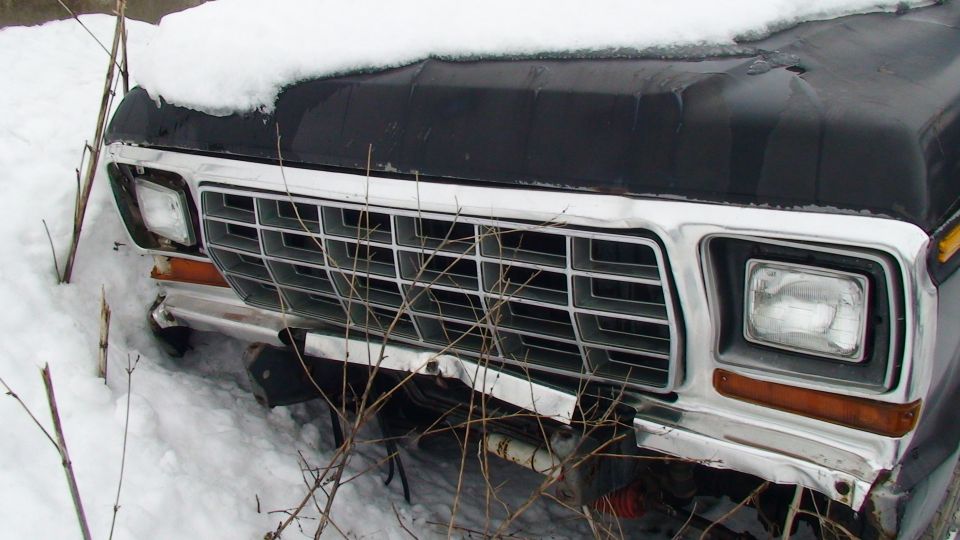 1979 Ford Bronco front grille and headlight assembly covered in snow