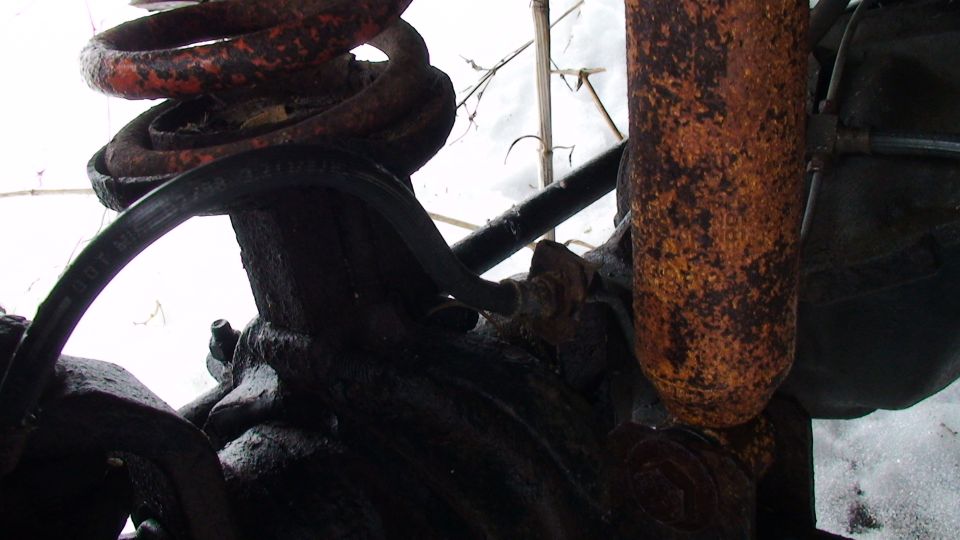 Rusty coil spring and shock absorber assembly with black grease