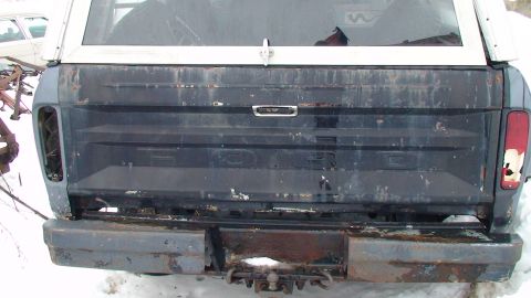 1979 Ford Bronco - Rear view of a 1979 Ford Bronco, the tailgate and a white camper shell.