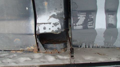 1979 Ford Bronco - The lower body panel of a vehicle shows significant rust and damage, indicating a need for repair.