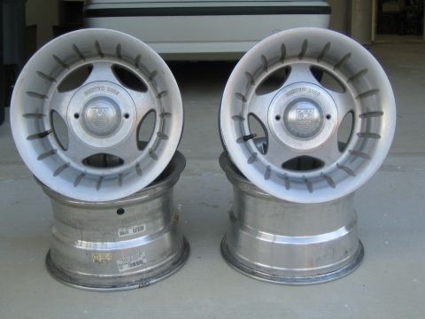 1995 Ford Bronco - A pair of Center Line aluminum alloy wheels are shown stacked, with a partial view of a white vehicle in the background.