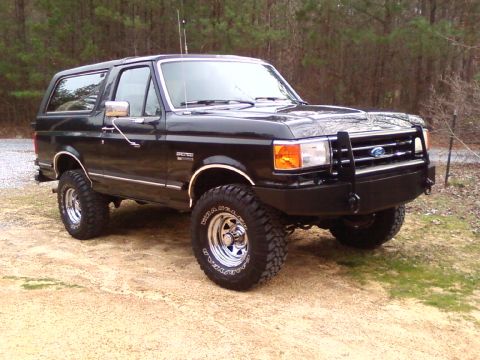 1990 Ford Bronco - This black Ford Bronco features an aftermarket front bumper and off-road tires.