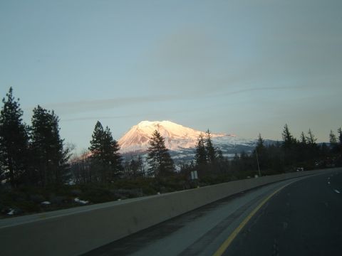 1989 Ford Bronco - A scenic mountain view from the highway as the sun sets, casting a warm glow on the snow-snowy peaks.